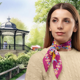 Woman wearing a colourful scarf with a park and Buxton band stand in Buxton Pavilion Park.